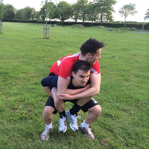 Stuart Lee performing squats with Ash Mills acting as additional body weight.