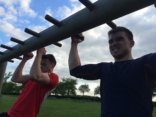 Ash Mills (left) and Stuart Lee (right) performing chin-ups.